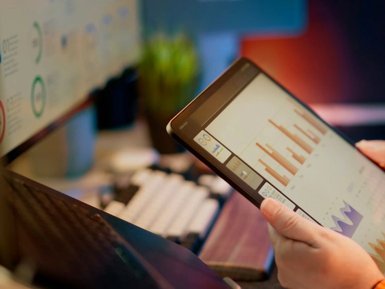 Tableau de bord numérique analysé sur tablette dans un environnement de travail